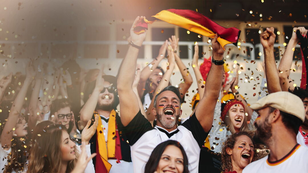 Stadionszenerie Mann mit Fanschminke und Deutschlandfahne jubelt